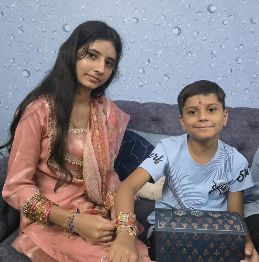 Hand tying a traditional and handmade DIY rakhi during Raksha Bandhan 2026 shubh muhurat with a decorated puja thali.